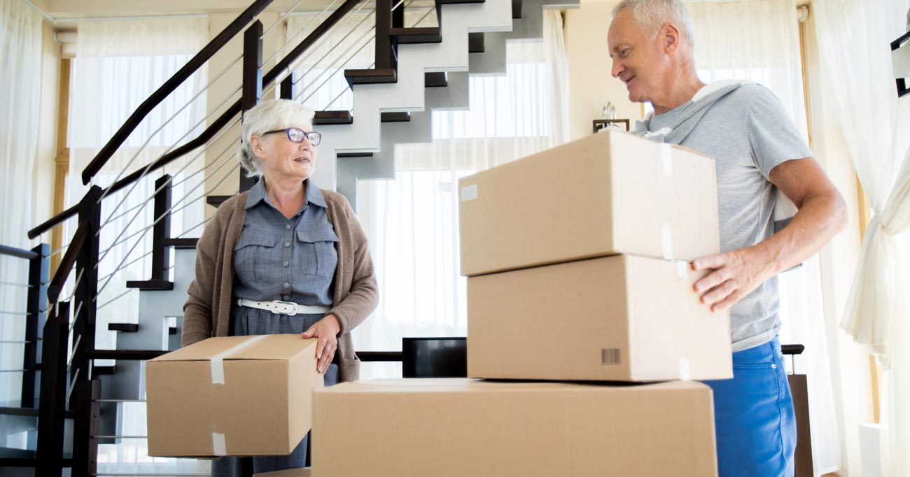 VRS Orchard Gardens portrait of happy senior couple packing cardboard boxes