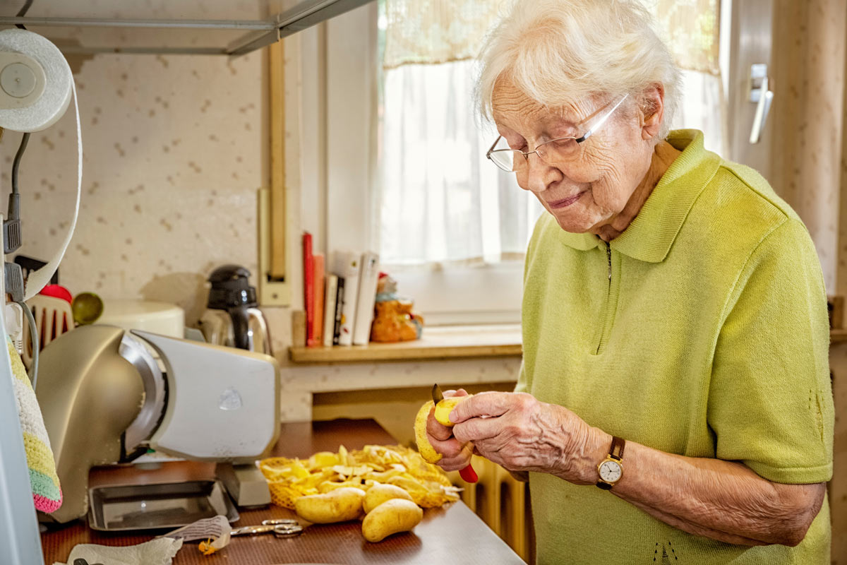 VRS Orchard Gardens Senior peeling potatoes for cooking in assisted living suite