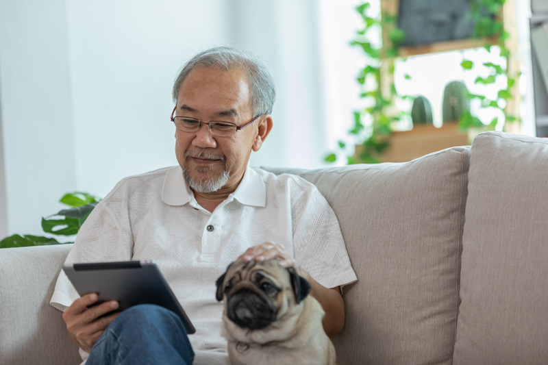 Senior on iPad tablet with dog at VRS retirement home in Kelowna
