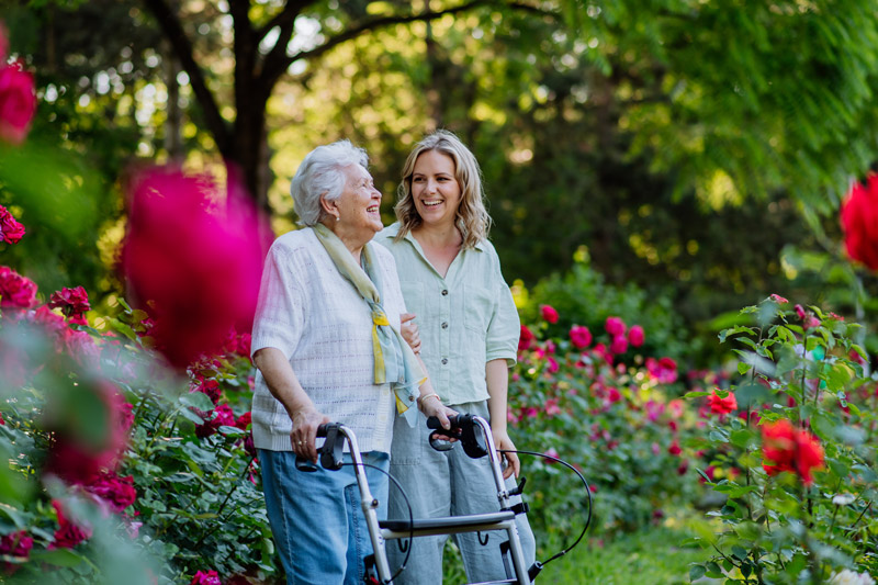 Senior safely walking outside with a walker at a senior independent or assisted living community in Kelowna